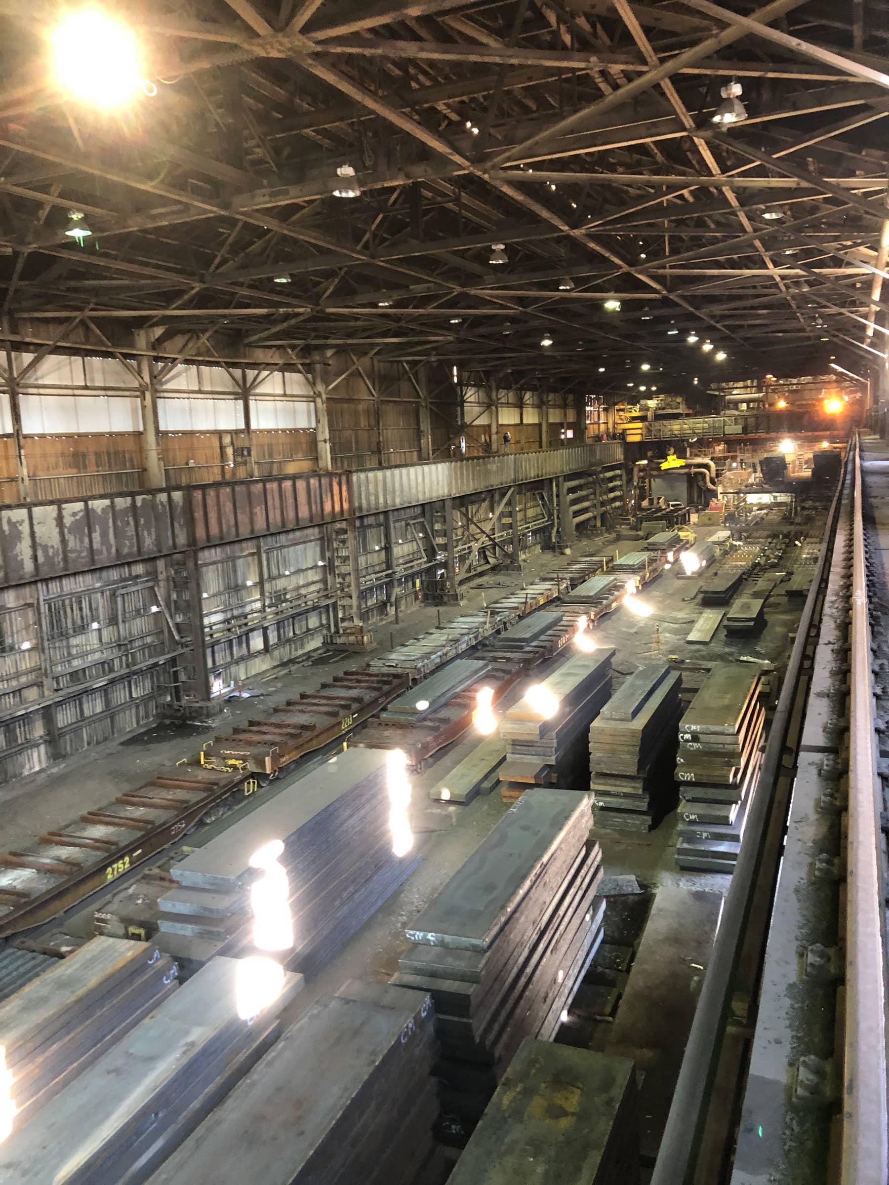 Slab storage bay with rail cars under the crane runway